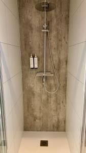 a shower in a bathroom with a concrete wall at Cube & Quiet - Where nature meets comfort in Haarle +47 photos