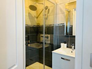 a bathroom with a glass shower and a sink at Cosy Paris CDG Stade de France in Le Blanc-Mesnil +33 photos