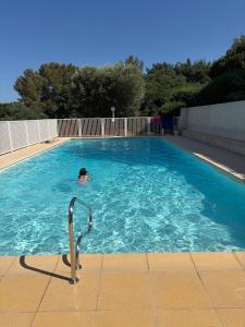a person is swimming in a swimming pool at Studio avec piscine à 1km de la plage in Cavalaire-sur-Mer