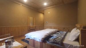 a bedroom with a bed in the corner of a room at Tirthan river edge in Bathād