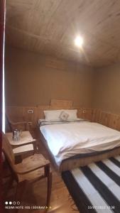 a bedroom with a large bed and a table at Tirthan river edge in Bathād