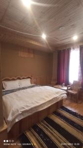 a bedroom with a large bed and a window at Tirthan river edge in Bathād