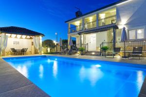 a swimming pool in front of a house at night at Villa Morgan by Rent Istria in Umag