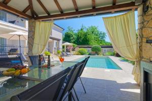 a patio with a table and a swimming pool at Villa Morgan by Rent Istria in Umag
