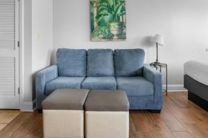a blue couch sitting in a living room with a stool at The Palace 2306 in Myrtle Beach