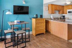 a kitchen with a table and a counter with stools at The Palace 2306 in Myrtle Beach +10 photos