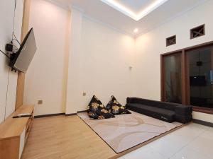 a living room with a couch and a flat screen tv at Nafaka Hostel and Tours in Malang