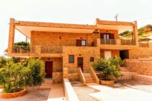 a brick house with stairs and trees in front of it at VillaAnna in Keratea