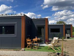 a black tiny house with a table and chairs at Vistalake in Michale