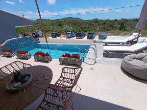 a patio with two chairs and a swimming pool at GeoMar Luxury Apartments in Skala Marion