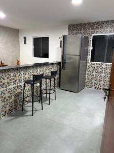 a kitchen with three chairs and a refrigerator at Apartamento com vista e privacidade , ideal para casais , próximo da praia in Rio de Janeiro +14 photos