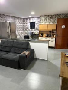 a living room with a couch and a kitchen at Apartamento com vista e privacidade , ideal para casais , próximo da praia in Rio de Janeiro