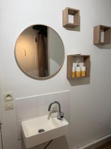 a bathroom with a sink and a mirror at Le havre des embruns in Saint-Xandre +2 photos