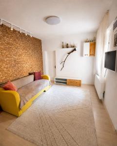 a living room with a yellow couch and a wall at Casa Family in Eforie Sud