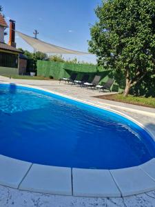 a blue swimming pool with chairs in a yard at Diamond House Rent -vikendica sa privatnim bazenom in Beška