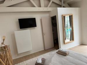 a bedroom with a tv on the wall and a bed at Le havre des embruns in Saint-Xandre