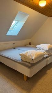 a large bed in a room with a skylight at Holiday Apartment Rudkøbing in Rudkøbing