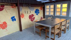 a table and chairs in a room with flowers on the wall at Holiday Apartment Rudkøbing in Rudkøbing