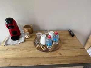 a wooden table with a tray with bottles and glasses on it at Le havre des embruns in Saint-Xandre