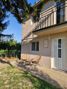 two chairs and a table in front of a building at Diamond House Rent -vikendica sa privatnim bazenom in Beška