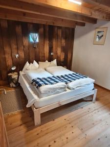 a large bed in a room with wooden walls at Rifugio in Voga in Gordona
