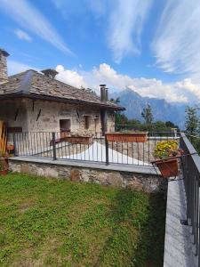a house with a fence and flowers on a balcony at Rifugio in Voga in Gordona