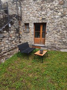 a black chair and a table in front of a stone building at Rifugio in Voga in Gordona +18 photos