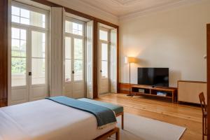 a bedroom with a bed and a flat screen tv at Casa do Arquiteto Townhouse - Adults Only in Porto