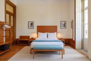 a bedroom with a large bed with a wooden headboard at Casa do Arquiteto Townhouse - Adults Only in Porto