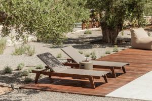 two lounge chairs and a table on a wooden deck at Levante Afitos Suites - Adults Only in Afitos