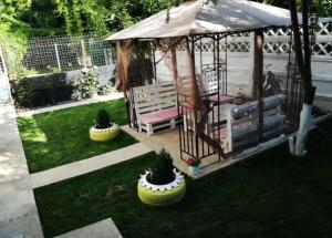 a gazebo with two chairs and plants in a yard at Saturn Cozy Stay in Mangalia