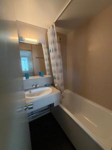a bathroom with a sink and a bath tub at Parenthèse nature à Prémanon in Prémanon +10 photos