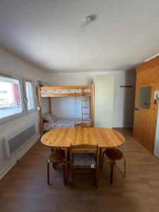a room with a wooden table and a bunk bed at Parenthèse nature à Prémanon in Prémanon