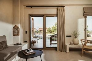 a living room with a sliding glass door to a patio at Levante Afitos Suites - Adults Only in Afitos