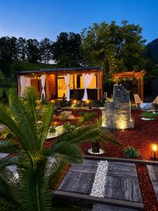 a house with a palm tree in front of it at Sarajevo jacuzzi sauna Forest romance lodge in Sarajevo