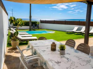 a patio with a table and chairs and a pool at Villa del Relax in Corralejo