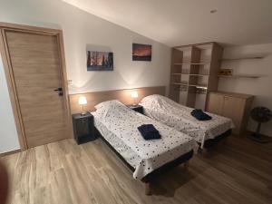 a bedroom with two beds and a door with two lamps at Appartement SUOMI in Saint-Sorlin-en-Bugey