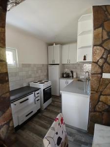 a kitchen with white cabinets and white appliances at Vukota - Kuca za odmor in Plav