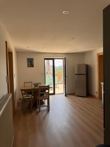 a kitchen and dining room with a table and a refrigerator at Gîte la Tinou in Saint-Nabord +4 photos