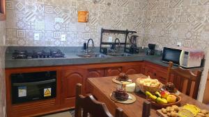a kitchen with a sink and a table with a microwave at Casa Rústica Próxima a Milho Verde, 3 QUARTOS - São Gonçalo do Rio das Pedras, Serro in Sêrro