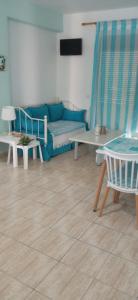 a living room with a blue couch and tables at THALASSA - 2 Bedroom seaside appartment in Polychrono