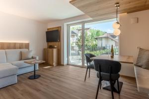 a living room with a couch and a table at Laurena Aparthotel near Brixen in Natz-Schabs