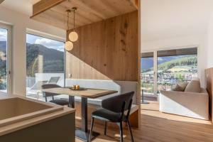 a kitchen and dining room with a table and chairs at Laurena Aparthotel near Brixen in Natz-Schabs