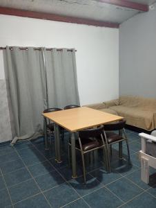 a table and chairs in a room with a couch at La Tranquila in Fernández