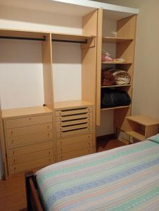 a bedroom with a bed and a closet with shelves at La Tranquila in Fernández