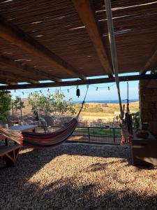 a hammock hanging from a building with a view of the desert at Ellie Villa Seaside Koufonisi in Nisída Koufonísion
