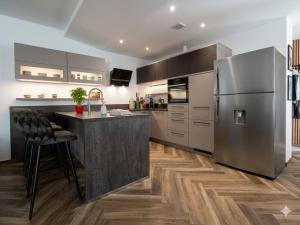 a kitchen with a stainless steel refrigerator and wooden floors at Apartmant & rooms Villa Rosa Medulin in Pomer