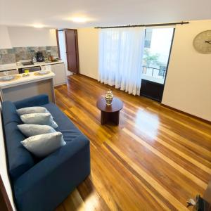 a living room with a blue couch and a table at Arbórea Casa Boutique in Cuenca