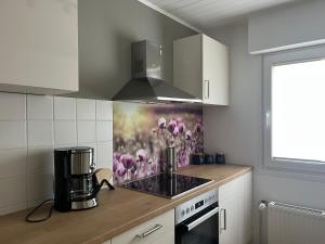 a kitchen with a painting of flowers on the wall at Haus Blumenglück 2.0 in Herscheid