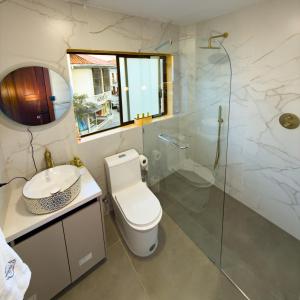 a bathroom with a toilet and a glass shower at Arbórea Casa Boutique in Cuenca +18 photos